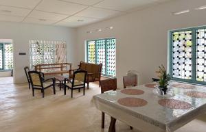 a room with a table and chairs and windows at Achcha's Place in Negombo