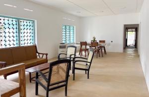 a waiting room with chairs and tables and windows at Achcha's Place in Negombo +17 photos