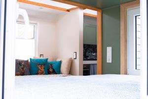 a bedroom with a white bed with blue pillows at Ilsehof Tiny-House Mimi in Osterwieck