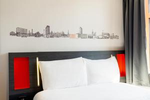 a bedroom with a bed with a city drawing on the wall at easyHotel Sheffield in Sheffield