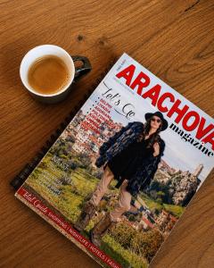a magazine sitting on a table with a cup of coffee at Veranda Villa in Arachova