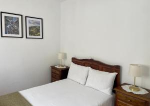 a bedroom with a bed with two night stands and two lamps at Raízes da Serra - Casa Lapa in Lapa dos Dinheiros