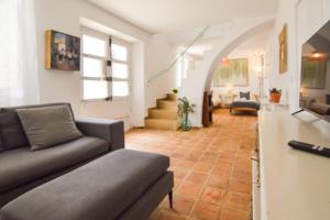 a living room with a couch and a staircase at La Calma de Vilo in Periana