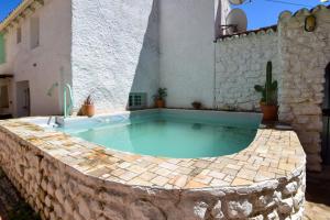 a swimming pool in the middle of a stone wall at La Calma de Vilo in Periana
