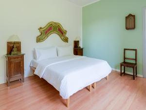 a bedroom with a large white bed and two tables at Scenarium in Udine