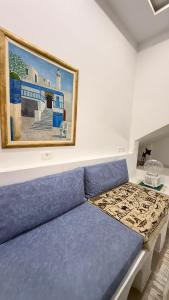 a blue couch in a room with a painting on the wall at Sidi bou duplex in La Goulette