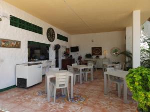 a dining room with white tables and white chairs at Hotel Refugio Bike in Mariquita