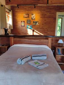 a bedroom with a bed with towels on it at Chalé Das Quaresmeiras in Aiuruoca