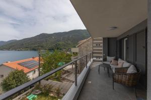 a balcony with a view of the water and mountains at Villa Morion with Sauna and Pool in Donji Morinj