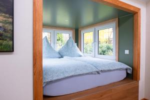 a bedroom with a bed with pillows and a window at Ilsehof Tiny-House Mimi in Osterwieck