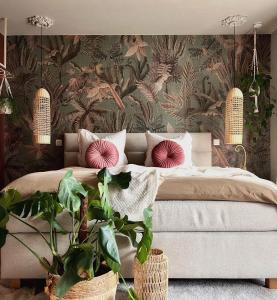 a bedroom with a large bed with a floral wallpaper at B&B De Rooman in Sint-Gillis-Waas