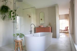 a large white bath tub in a bathroom at B&B De Rooman in Sint-Gillis-Waas +27 photos