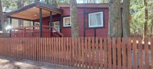 a red house with a fence in front of it at Oleandria-,, Domek Mięta" in Biskupiec