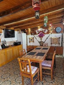 a dining room with a wooden table and chairs at Casa Marinela in Haţeg