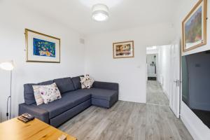 a living room with a couch and a table at Modern 2 bedroom flat, SE6 in Catford