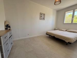 a bedroom with a bed and a dresser and a window at Le Nid du Cotentin - Maison moderne & calme in Les Pieux