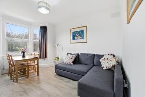 a living room with a couch and a table at Modern 2 bedroom flat, SE6 in Catford