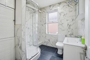 a bathroom with a shower toilet and a sink at Modern 2 bedroom flat, SE6 in Catford +8 photos