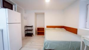 ein kleines Schlafzimmer mit Bett und Kühlschrank in der Unterkunft Cocoaloa in Armilla