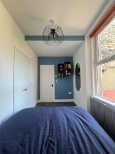 a bedroom with a bed with a blue blanket at Full Apartment in the Heart of Margate in Margate