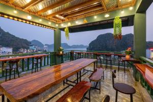 a restaurant with a wooden table and chairs on a balcony at Song Nga Boutique Hotel Cat Ba in Cat Ba