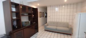a living room with a chair and a refrigerator at Casa XV de novembro em Garanhuns in Garanhuns