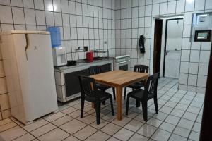 a kitchen with a table and chairs and a refrigerator at Casa XV de novembro em Garanhuns in Garanhuns