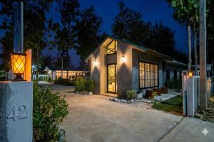 a house with a lot of windows and a driveway at Ban Tew Kao in Ban Nong Chaeng