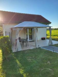a gazebo with a table in a yard at L'Impasse du Jura in Ménétru-le-Vignoble