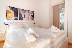 a white bed with two white pillows on it at Bissone Campione Lake Pool & Relax in Bissone