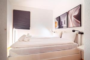 a bed in a room with two pictures on the wall at Bissone Campione Lake Pool & Relax in Bissone