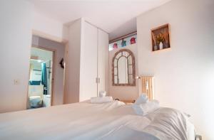 a white bedroom with a large bed and a mirror at Bissone Campione Lake Pool & Relax in Bissone