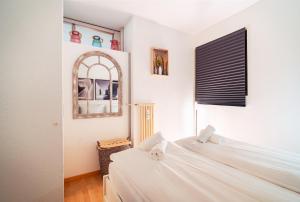 a bedroom with two white beds and a mirror at Bissone Campione Lake Pool & Relax in Bissone