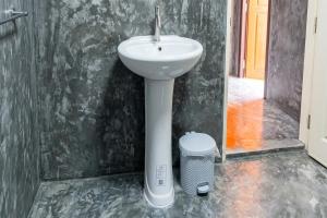 a bathroom with a white sink and a trash can at Ban Tew Kao in Ban Nong Chaeng +54 photos
