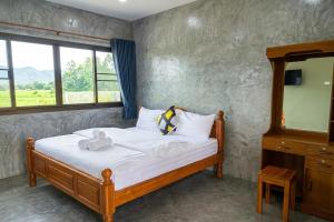 a bedroom with a bed with a teddy bear on it at Ban Tew Kao in Ban Nong Chaeng