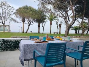 a table with blue chairs and a table with food on it at El Pinar Beach in Comillas