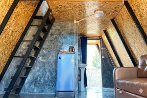 a room with a refrigerator and a staircase at Ban Tew Kao in Ban Nong Chaeng