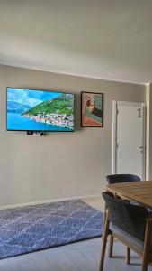 a living room with a flat screen tv on a wall at Villa Morion with Sauna and Pool in Donji Morinj