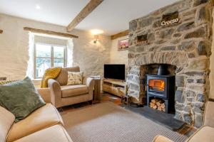 a living room with a stone fireplace and a tv at 2 Bed in Cwmystwyth oc-p32779 in Pentre-briwnant