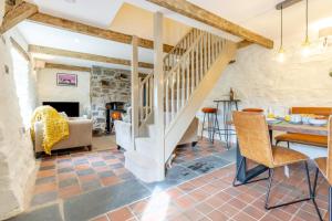 a large living room with a staircase and a table and chairs at 2 Bed in Cwmystwyth oc-p32779 in Pentre-briwnant