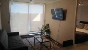 a living room with a couch and a tv on the wall at privilegio apart in Los Ángeles