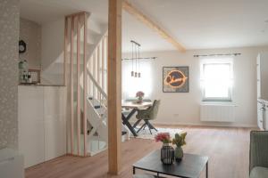 a living room and dining room with a staircase and a table at Altstadt Suite Bitburg in Bitburg
