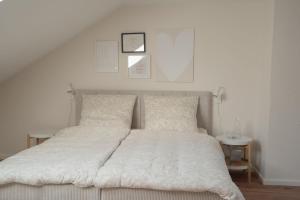 a bedroom with a white bed with two pillows at Altstadt Suite Bitburg in Bitburg