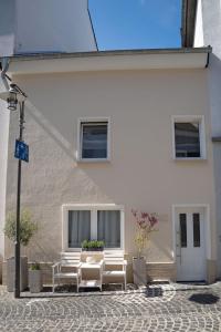 a group of white chairs sitting in front of a building at Altstadt Suite Bitburg in Bitburg