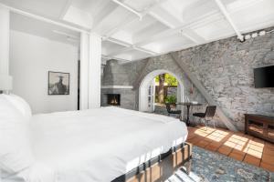 a bedroom with a large bed and a stone wall at Sonoma Stonehouse Hotel in Santa Rosa