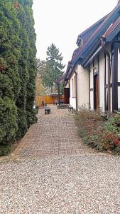 a brick walkway next to a building with a bench at Zamkowa in Puck
