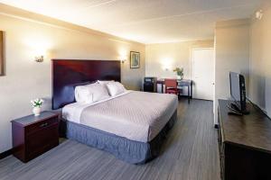 a hotel room with a bed and a flat screen tv at Home Suites Culebra in San Antonio