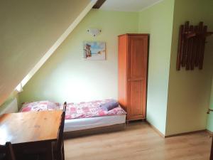 a small room with a bed and a wooden table at Zamkowa in Puck