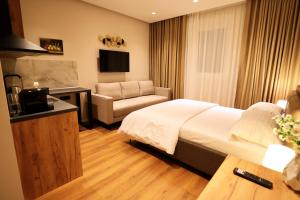 a hotel room with a bed and a couch at Theatro Hotel Apartaments Tirana in Tirana