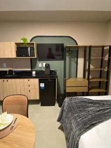 a bedroom with a bed and a tv and a table at One Studios Indaiatuba in Indaiatuba